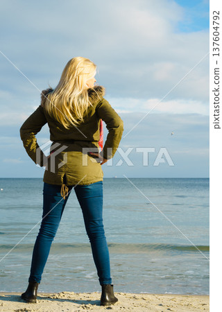 Woman relaxing on beach, cold day Woman relaxing on beach, cold day 137604792