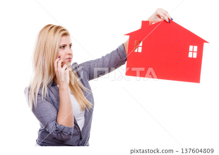 Thinking woman holds red house symbol 137604809