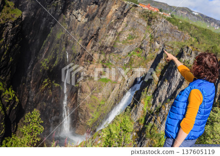 Tourist woman by Voringsfossen waterfall, Norway Tourist woman by Voringsfossen waterfall, Norway 137605119