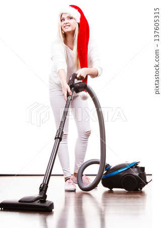 Girl in santa helper hat with vacuum cleaner Girl in santa helper hat with vacuum cleaner 137605315