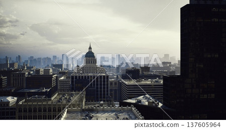 Dusk urban skyline with shadowed tower at left and capitol dome centered, soft fading light and atmospheric haze, layered rooftops and distant towers creating Dusk urban skyline with shadowed tower at left and capitol dome centered, soft fading light and atmospheric haze, layered rooftops and distant towers creating 137605964