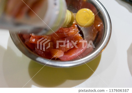 Place the tuna in a bowl and marinate it in soy sauce. 137606387