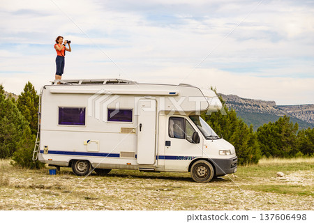 Woman traveling with caravan, taking photo from rv roof Woman traveling with caravan, taking photo from rv roof 137606498