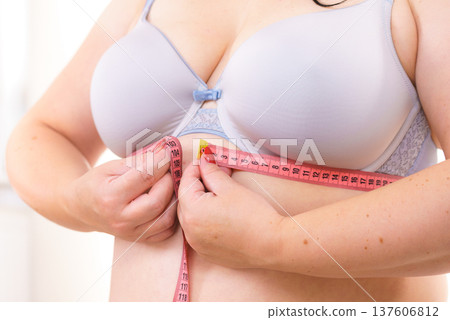 Woman plus size measuring her chest under breasts Woman plus size measuring her chest under breasts 137606812