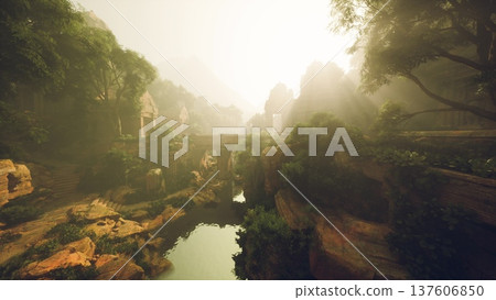 Sunlit stone bridge over river valley, golden rays pierce morning mist, ancient mosscovered masonry blends with lush trees, distant rocky cliffs rise 137606850