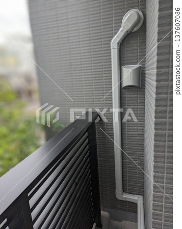 Installation example of an air conditioner piping decorative cover (slim duct) installed on the exterior wall of an apartment building's balcony 137607086