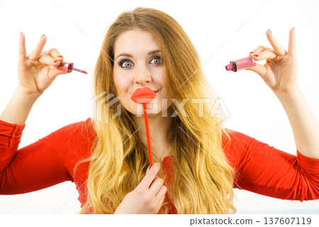 Woman applying lipstick or lip gloss Woman applying lipstick or lip gloss 137607119