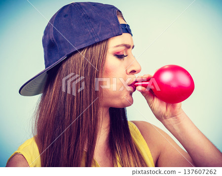 Teen girl blowing red balloon. Teen girl blowing red balloon. 137607262