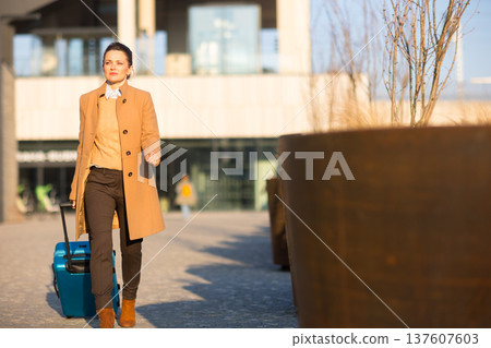 Professional Woman in Transit with Blue Luggage 137607603