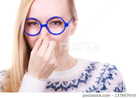 Nerdy woman holding nose smelling bad scent 137607650