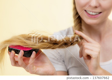 Blonde girl with long braid hair holds brush 137607662