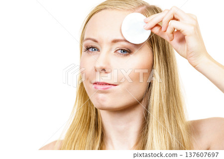 Woman cleaning her face skin with cotton pad 137607697