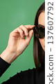 Close up of an anonymous hand adjusting stylish round sunglasses on a head 137607792