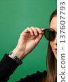 Close up of an anonymous hand adjusting stylish round sunglasses on a head 137607793
