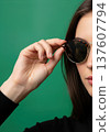 Close up of an anonymous hand adjusting stylish round sunglasses on a head 137607794
