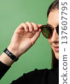 Close up of an anonymous hand adjusting stylish round sunglasses on a head 137607795