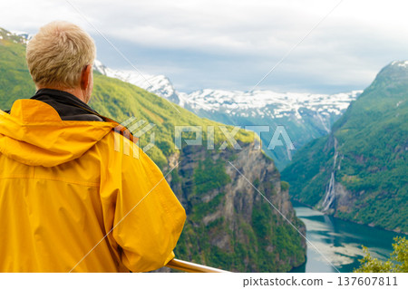 Tourist looking at Geirangerfjord from Flydasjuvet viewpoint Norway Tourist looking at Geirangerfjord from Flydasjuvet viewpoint Norway 137607811