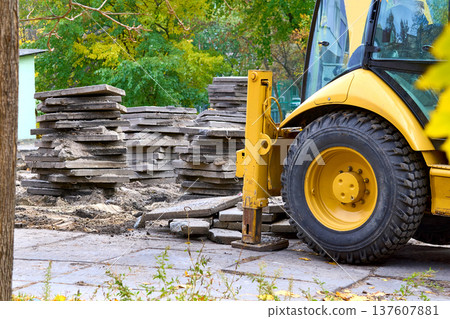 Demolition.Excavator bulldozer hydraulic stops loads old concrete slabs 137607881