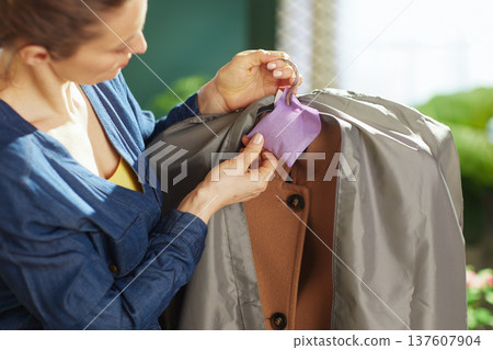 Woman Using Lavender Sachet for Coat Storage and Protection Woman Using Lavender Sachet for Coat Storage and Protection 137607904