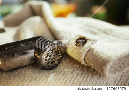 Electric Lint Remover Tool on Pilled Wool Garment Electric Lint Remover Tool on Pilled Wool Garment 137607979