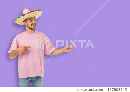 Cinco de Mayo, Young man in sombrero points with a smile, celebrating Cinco de Mayo, Young man in sombrero points with a smile, celebrating 137608245