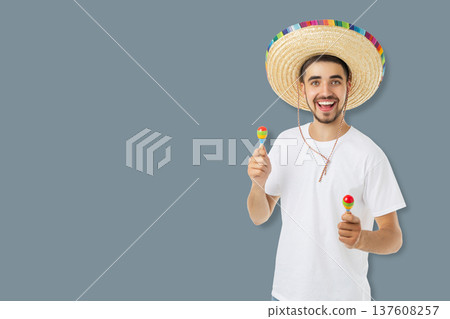 Young man enjoys Cinco de Mayo with maracas in hand 137608257