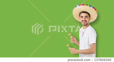 Cinco de Mayo, Man smiles while celebrating with maracas and sombrero 137608260