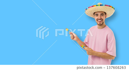 Cinco de Mayo, Young man smiles with maracas and a sombrero Cinco de Mayo, Young man smiles with maracas and a sombrero 137608263