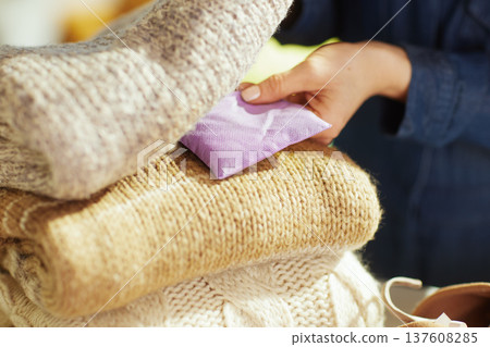 Detail of Hands Placing Lavender Sachet in Knitted Sweaters Detail of Hands Placing Lavender Sachet in Knitted Sweaters 137608285