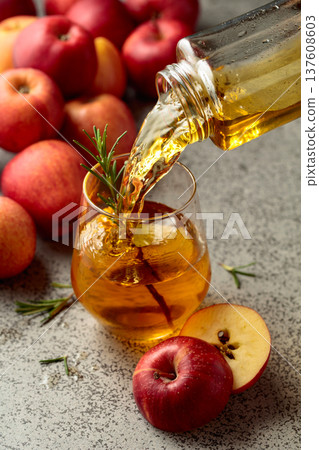 Apple juice is poured from a bottle into a glass. 137608603