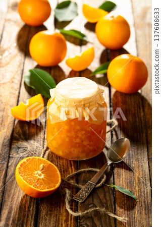 Orange jam and fresh fruits on an old wooden table. Orange jam and fresh fruits on an old wooden table. 137608633
