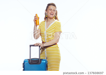 Vacation Ready Woman with Blue Luggage and Sunscreen Spray 137608697
