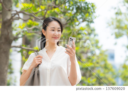 Woman, casual, early summer, walking, smartphone Woman, casual, early summer, walking, smartphone 137609020