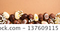 Colorful Easter eggs arranged with delicate white flowers on a brown background for festive decoration 137609115