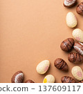 Colorful chocolate Easter eggs arranged on a brown surface, showcasing various designs and textures 137609117