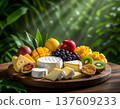 Assorted cheese platter with fresh fruits and vibrant greenery in a natural setting 137609233