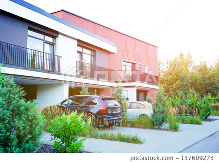 Townhouses with a car parked in garage in residential neighborhood.  137609273