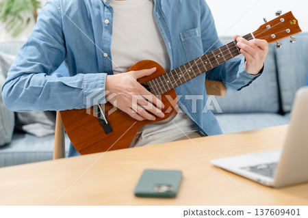 Man playing the ukulele 137609401