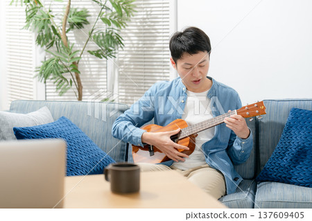 A man playing an ukulele A man playing an ukulele 137609405