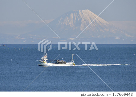 Photographing the scenery of Mt. Yotei and fishing boats passing through Funka Bay in Yakumo Town, Hokkaido in early spring Photographing the scenery of Mt. Yotei and fishing boats passing through Funka Bay in Yakumo Town, Hokkaido in early spring 137609448