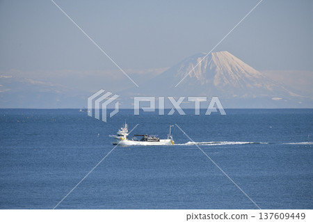 Photographing the scenery of Mt. Yotei and fishing boats passing through Funka Bay in Yakumo Town, Hokkaido in early spring Photographing the scenery of Mt. Yotei and fishing boats passing through Funka Bay in Yakumo Town, Hokkaido in early spring 137609449