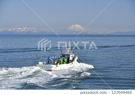 Photographing the scenery of Mt. Yotei and fishing boats passing through Funka Bay in Yakumo Town, Hokkaido in early spring Photographing the scenery of Mt. Yotei and fishing boats passing through Funka Bay in Yakumo Town, Hokkaido in early spring 137609468