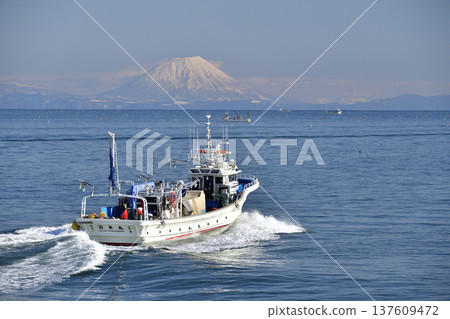 Photographing the scenery of Mt. Yotei and fishing boats passing through Funka Bay in Yakumo Town, Hokkaido in early spring Photographing the scenery of Mt. Yotei and fishing boats passing through Funka Bay in Yakumo Town, Hokkaido in early spring 137609472