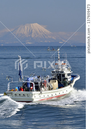 Photographing the scenery of Mt. Yotei and fishing boats passing through Funka Bay in Yakumo Town, Hokkaido in early spring Photographing the scenery of Mt. Yotei and fishing boats passing through Funka Bay in Yakumo Town, Hokkaido in early spring 137609473