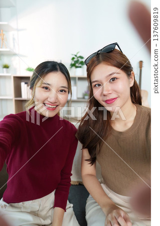 Selfie Moment. Two friends capturing joyful moment together at home. 137609819