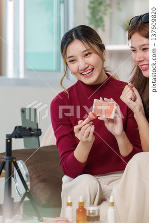 Makeup Sharing. Friends showcasing beauty products during a fun tutorial. Makeup Sharing. Friends showcasing beauty products during a fun tutorial. 137609820