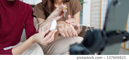 Skincare Tutorial. Two friends demonstrating beauty routine with serum application. 137609825