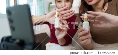 Product Presentation. Friends showcasing skincare bottles in a beauty video. Product Presentation. Friends showcasing skincare bottles in a beauty video. 137609826