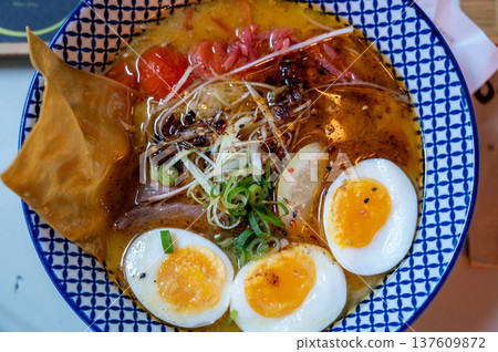 Lyon, france. December 29, 2023. Delicious ramen bowl with soft-boiled eggs, tender pork, noodles and scallions in rich, savory broth comforting japanese meal, close up 137609872