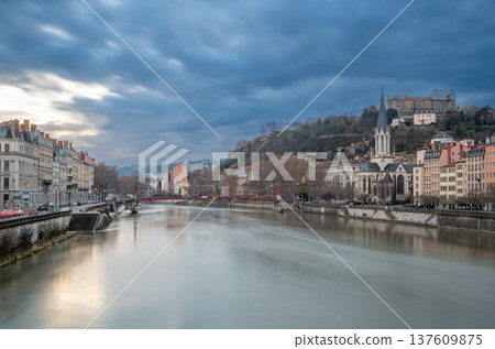 Lyon, france. December 29, 2023. Lyon cityscape showing the saone river, saint georges church, and historic buildings under a cloudy sky during blue hour Lyon, france. December 29, 2023. Lyon cityscape showing the saone river, saint georges church, and historic buildings under a cloudy sky during blue hour 137609875